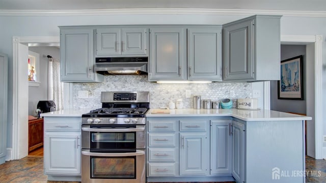 kitchen featuring tasteful backsplash, crown molding, under cabinet range hood, double oven range, and light countertops