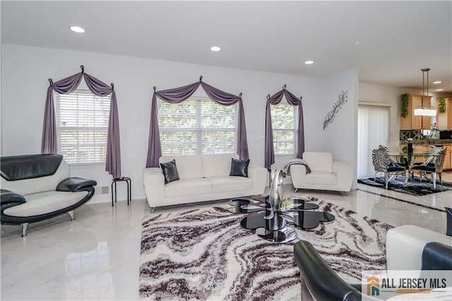 living room with marble finish floor, recessed lighting, and plenty of natural light