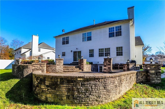 back of house with a chimney and fence