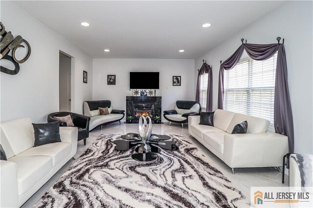 living area featuring a tiled fireplace and recessed lighting