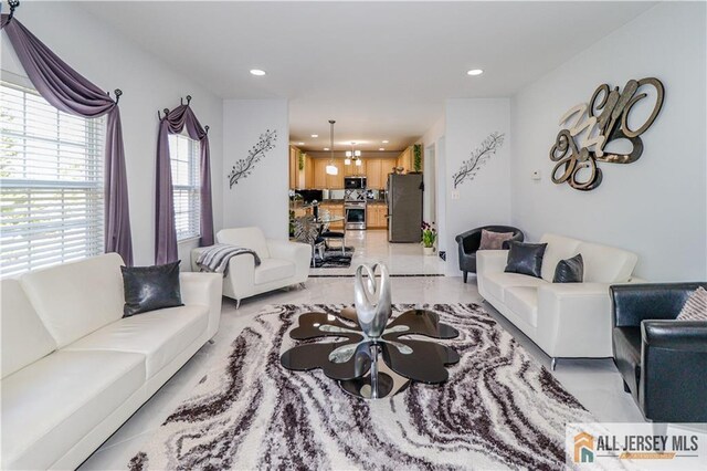 living area with recessed lighting and marble finish floor