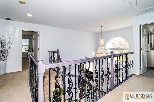 hallway featuring recessed lighting, baseboards, carpet, and an upstairs landing