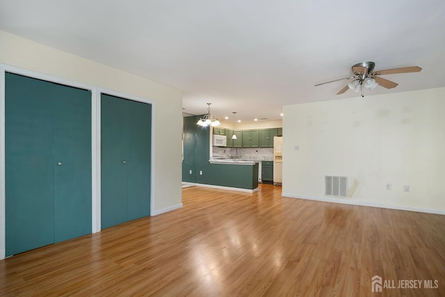224 Pennsylvania Way N, Brunswick, NJ 08902 - unfurnished living room with a chandelier, light wood-type flooring, and ceiling fan