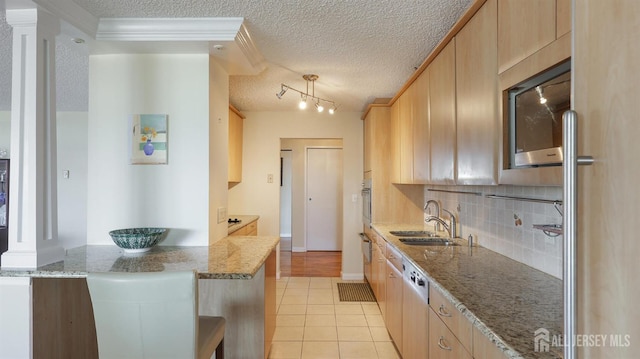 30 S Adelaide Ave Unit 7H, Highland Park, NJ 08904 - kitchen featuring stainless steel appliances, light tile patterned floors, backsplash, light brown cabinets, and a textured ceiling