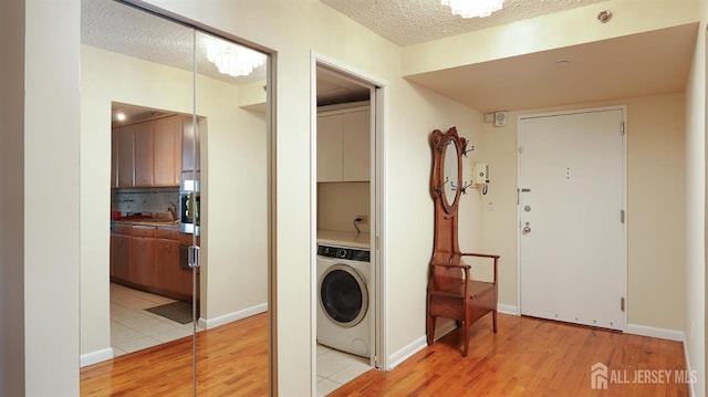 30 S Adelaide Ave Unit 7H, Highland Park, NJ 08904 - washroom featuring washer / clothes dryer, light wood-style flooring, a textured ceiling, and cabinet space