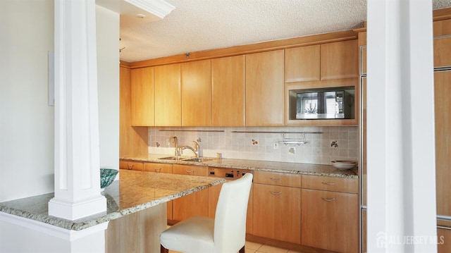 30 S Adelaide Ave Unit 7H, Highland Park, NJ 08904 - kitchen with built in microwave, light stone countertops, decorative backsplash, ornate columns, and a textured ceiling