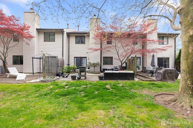 265 Plum Dr, Marlboro, NJ 07746 - back of property featuring a patio area, a chimney, a lawn, and an outdoor living space