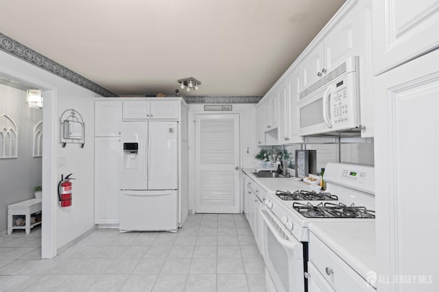 265 Plum Dr, Marlboro, NJ 07746 - kitchen with white appliances, white cabinetry, light countertops, and light tile patterned floors