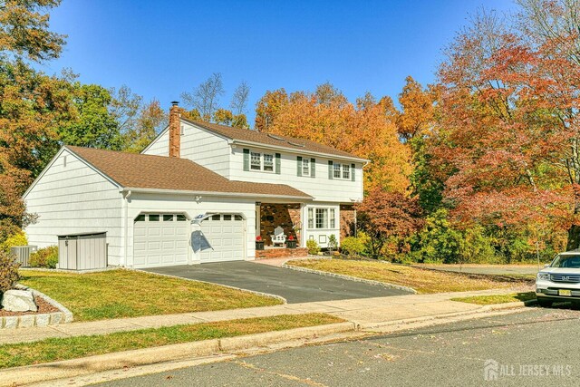 front facade with a front lawn and a garage