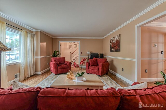 living room featuring light wood-type flooring and crown molding