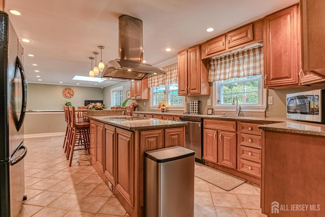 kitchen featuring sink, a center island, hanging light fixtures, island exhaust hood, and appliances with stainless steel finishes