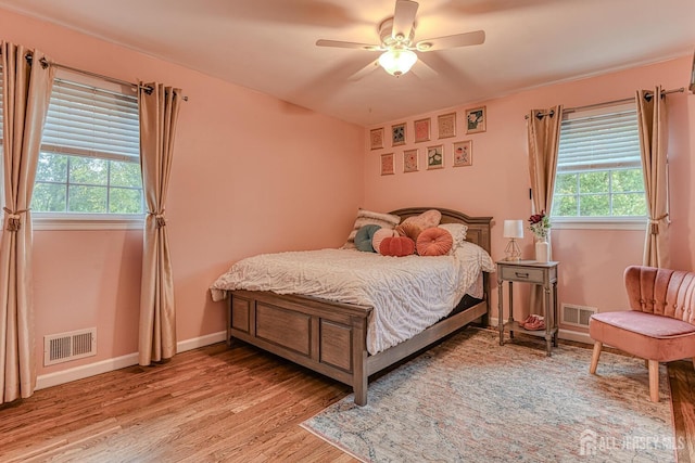 bedroom with multiple windows, light hardwood / wood-style flooring, and ceiling fan