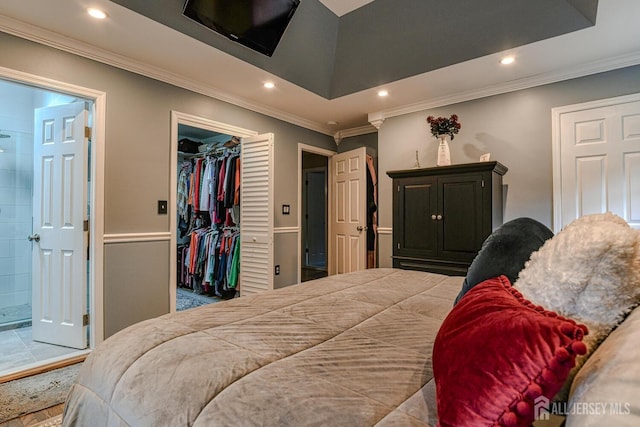 bedroom with a spacious closet, ornamental molding, and a closet