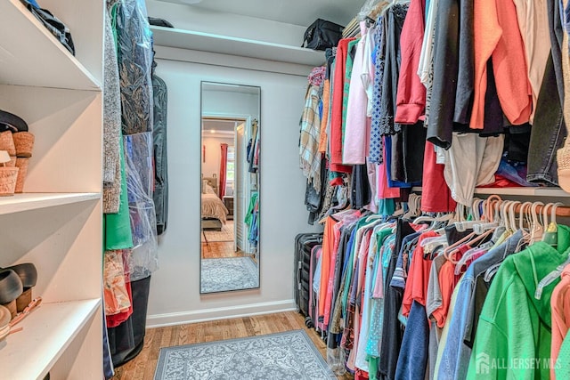 walk in closet with light hardwood / wood-style floors