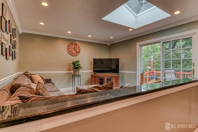 living room with a skylight and crown molding