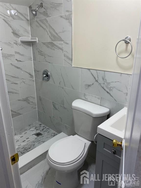 155 2nd St, South Amboy, NJ 08879 - bathroom with vanity, a shower stall, marble look tile flooring, and tile walls