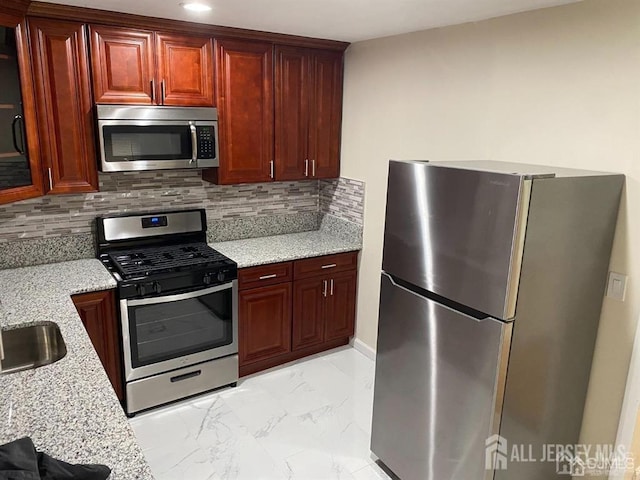 155 2nd St, South Amboy, NJ 08879 - kitchen featuring stainless steel appliances, light marble finish flooring, light stone countertops, tasteful backsplash, and reddish brown cabinets