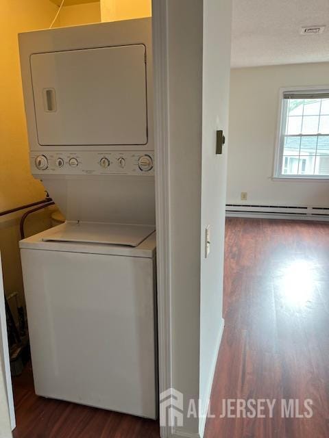 406 Oxford Ln Unit O, Monroe, NJ 08831 - washroom with stacked washing machine and dryer, dark wood finished floors, and baseboard heating