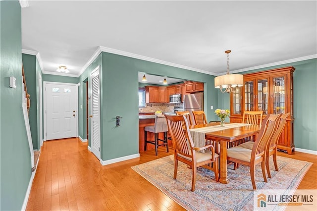 2507 Balmoral Ct, Hillsborough, NJ 08844 - dining area with light wood-type flooring, a chandelier, and ornamental molding