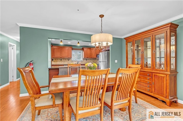 2507 Balmoral Ct, Hillsborough, NJ 08844 - dining room featuring ornamental molding, a chandelier, and light wood-style flooring