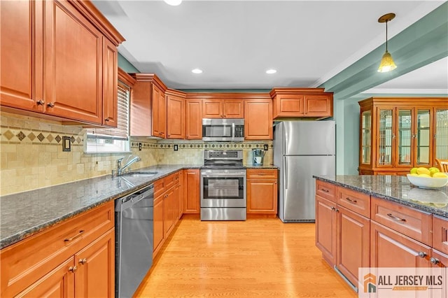 2507 Balmoral Ct, Hillsborough, NJ 08844 - kitchen with stainless steel appliances, light wood-style floors, pendant lighting, dark stone counters, and brown cabinets