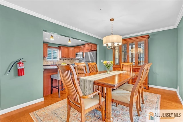 2507 Balmoral Ct, Hillsborough, NJ 08844 - dining room with light wood-type flooring, a chandelier, and crown molding