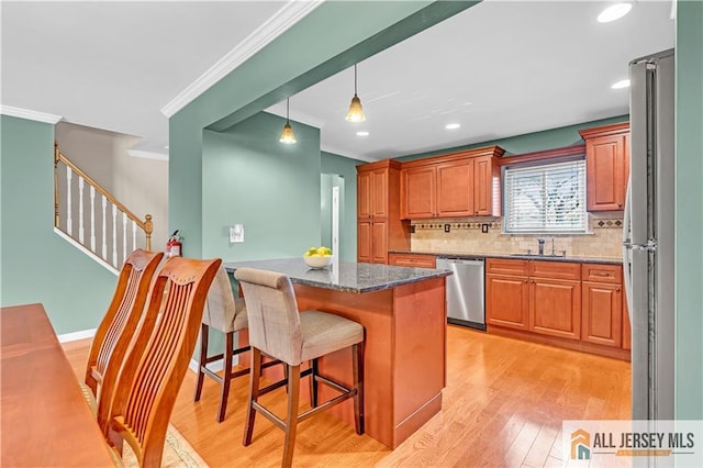 2507 Balmoral Ct, Hillsborough, NJ 08844 - kitchen with stainless steel dishwasher, crown molding, a breakfast bar, tasteful backsplash, and light wood-style floors