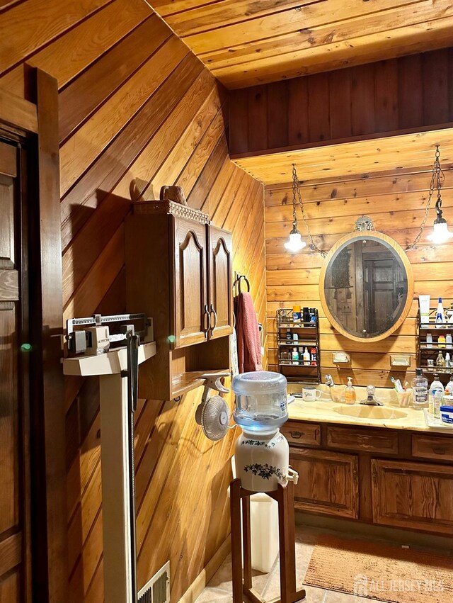 bathroom featuring sink, wooden ceiling, and wood walls