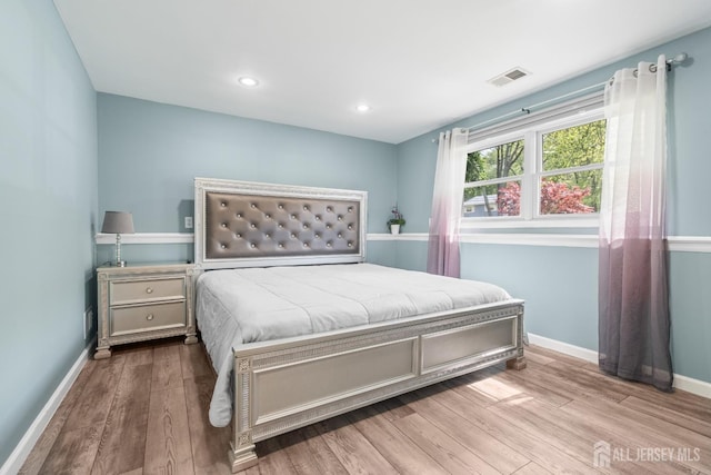 bedroom with wood finished floors, baseboards, and recessed lighting