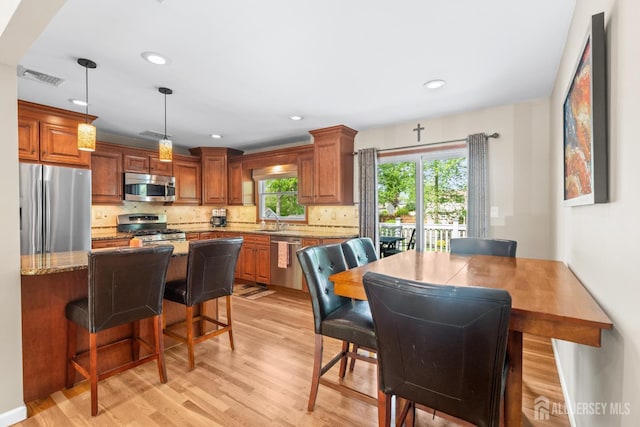 dining area with light wood-type flooring and recessed lighting
