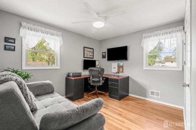 office area with healthy amount of natural light, light wood-type flooring, a ceiling fan, and baseboards