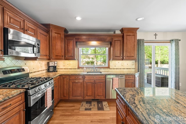 kitchen featuring appliances with stainless steel finishes, a sink, light wood-style floors, plenty of natural light, and recessed lighting