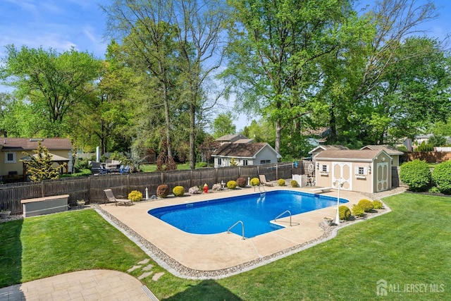 view of swimming pool with a patio area, a storage unit, an outbuilding, and a diving board