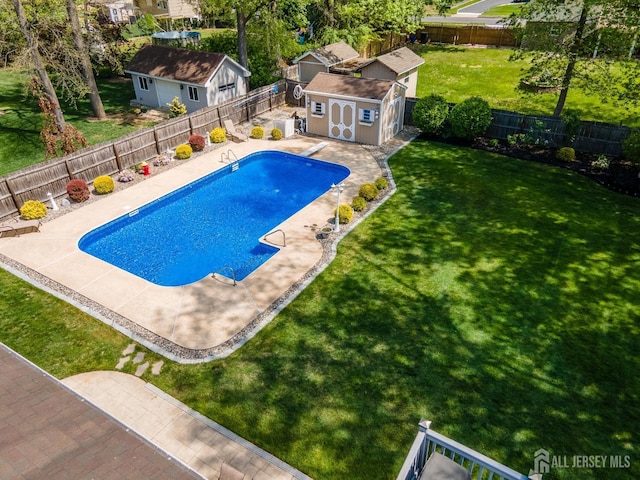 view of pool featuring an outbuilding, a shed, and a patio area