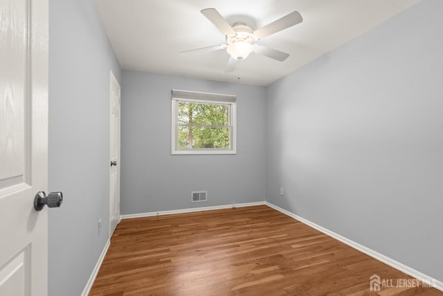 spare room featuring wood finished floors, baseboards, and ceiling fan