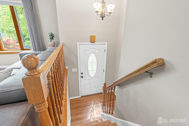 foyer featuring a chandelier, wood finished floors, and baseboards