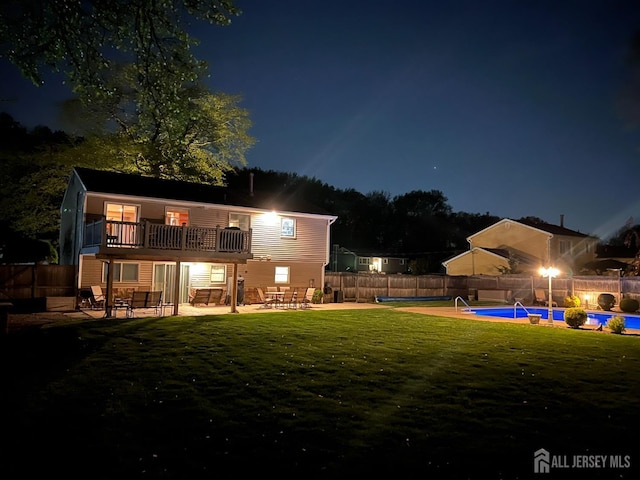 back of house at night with a patio area