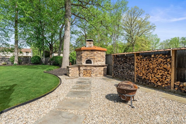 view of patio / terrace with an outdoor stone fireplace and an outdoor fire pit