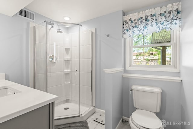 bathroom featuring tile patterned floors, a shower stall, toilet, and vanity