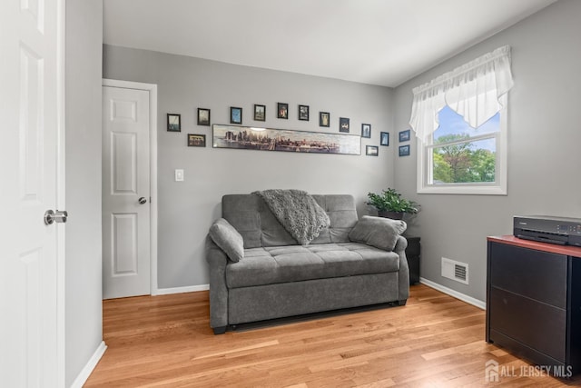 living area with light wood-style floors and baseboards