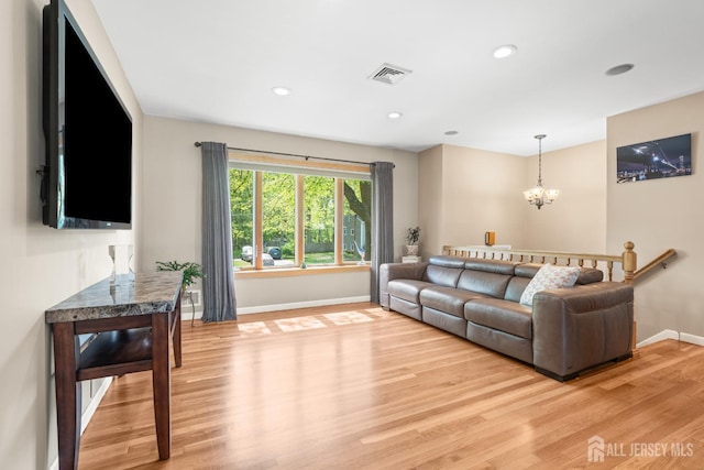 living area featuring baseboards, light wood-style flooring, a chandelier, and recessed lighting