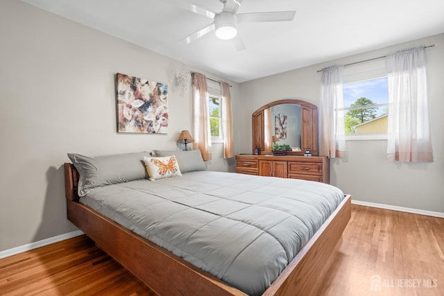 bedroom with baseboards, wood finished floors, and a ceiling fan