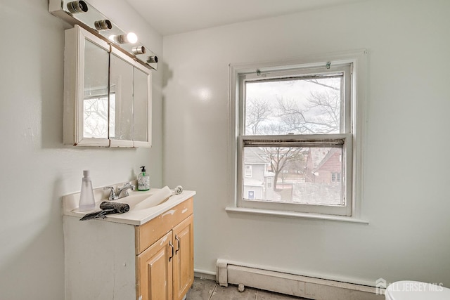 bathroom featuring baseboard heating and vanity