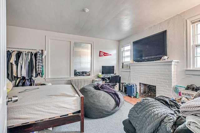 bedroom with carpet floors and a brick fireplace