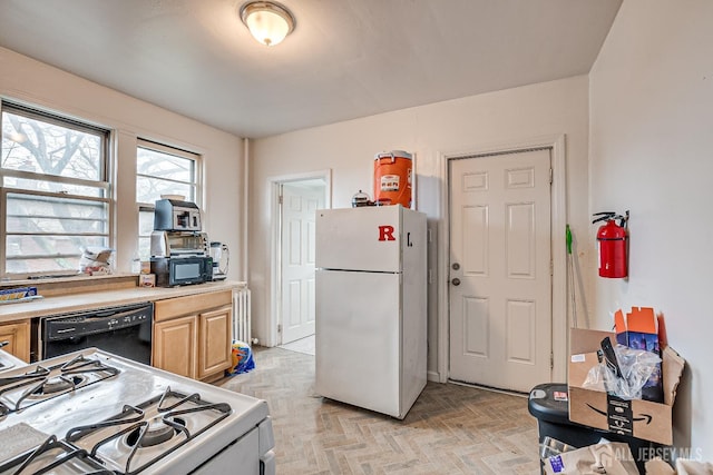 kitchen featuring light brown cabinetry, radiator, black appliances, and light parquet floors