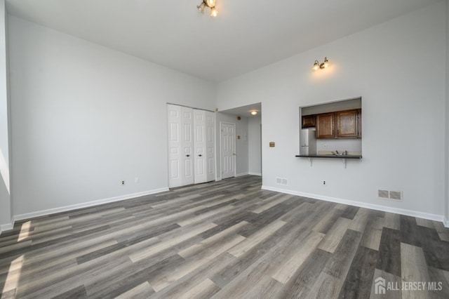 434 Lawrence St Unit 12, Perth Amboy, NJ 08861 - unfurnished living room with dark wood finished floors and baseboards