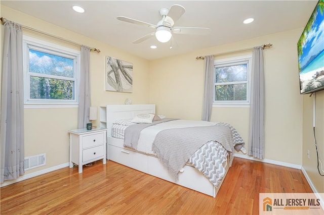 bedroom with multiple windows, light wood-type flooring, and ceiling fan