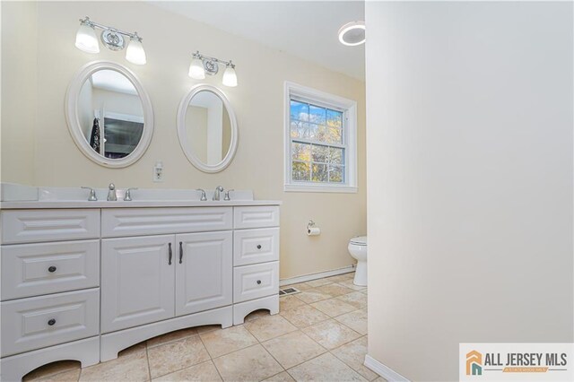 bathroom featuring tile patterned floors, vanity, and toilet