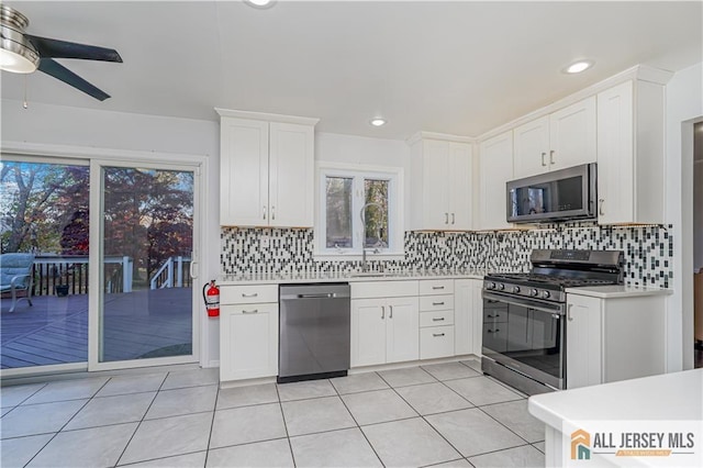 kitchen with white cabinetry, ceiling fan, appliances with stainless steel finishes, and tasteful backsplash