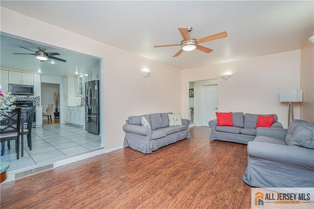 living room featuring ceiling fan and light hardwood / wood-style flooring